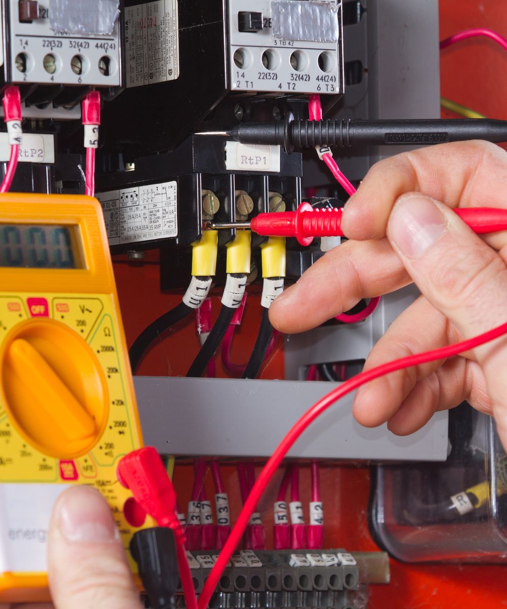 Elektriker misst Spannung in einem Schaltschrank